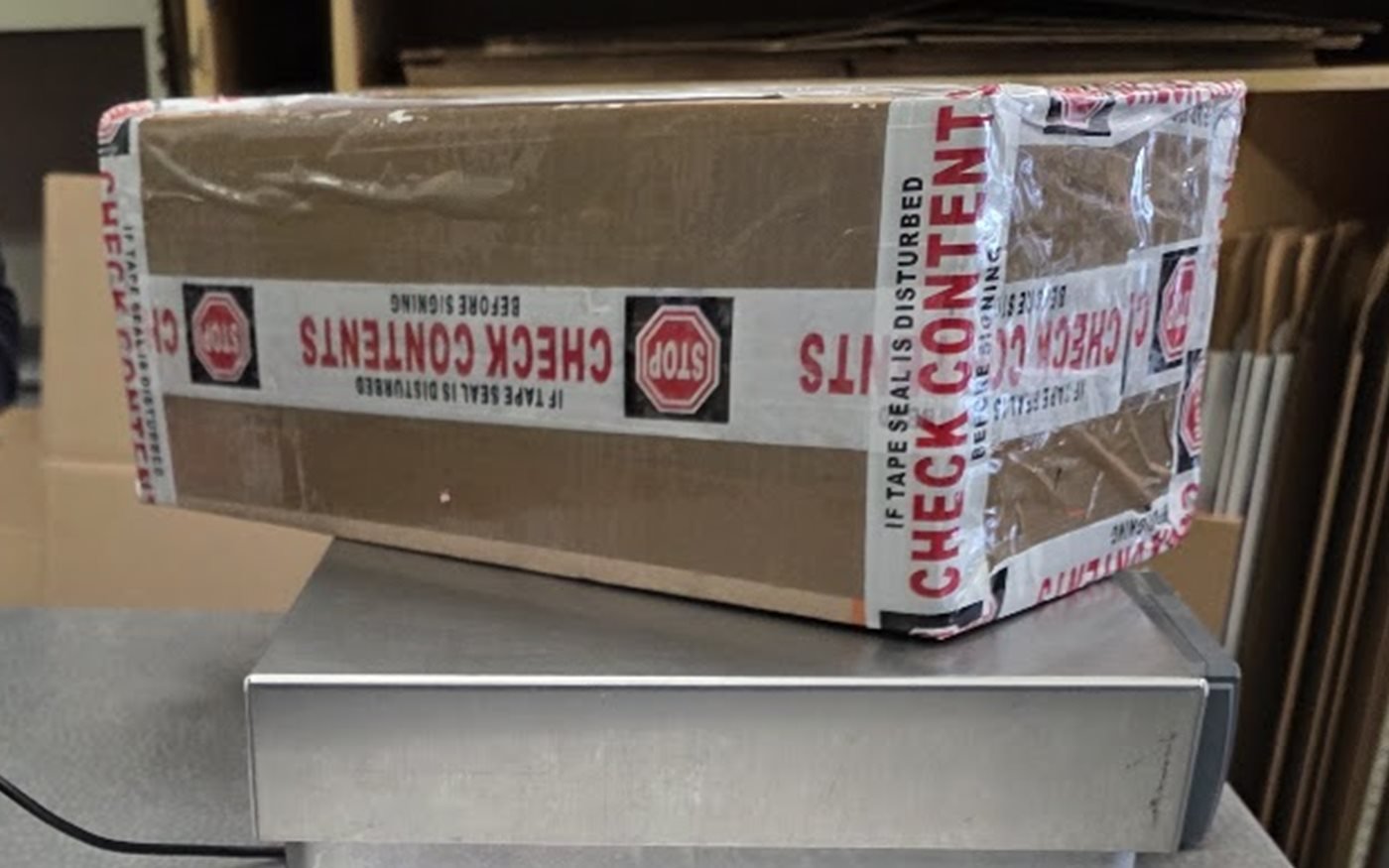 Packed device shipment being weighed for a Tecnifix mail-in repair