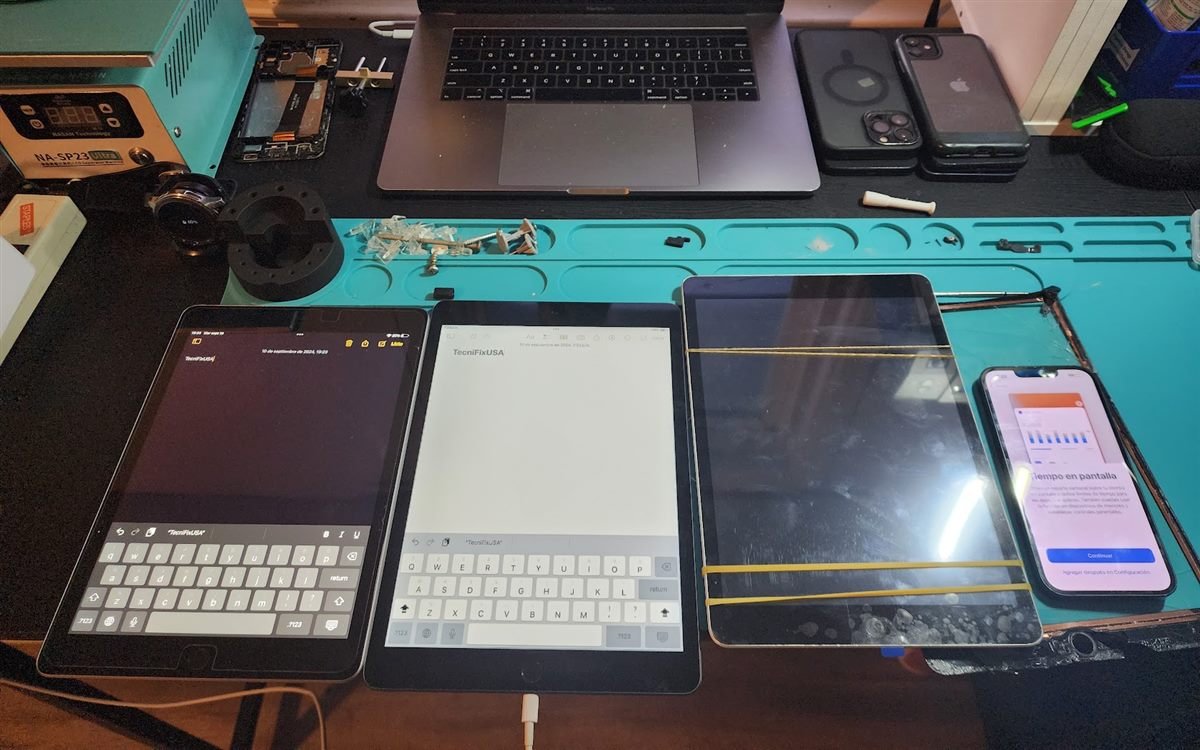 Several iPads on the Tecnifix repair bench during diagnostic testing